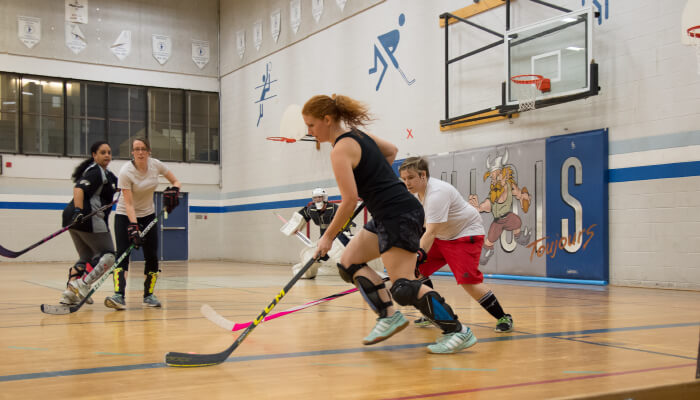 four ladies playing floor hockey